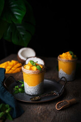 Homemade healthy breakfast, chia pudding with coconut milk and mango on a wooden