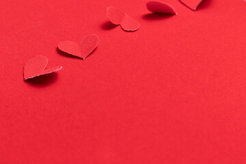 Red paper hearts on a red background. Valentine's Day.