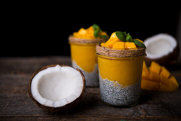 Homemade healthy breakfast, chia pudding with coconut milk and mango on a wooden table