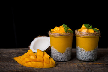 Homemade healthy breakfast, chia pudding with coconut milk and mango on a wooden table