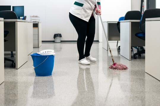 Woman cleaning school classroom with bucket and mop. Disinfection of covid-19, coronavirus.