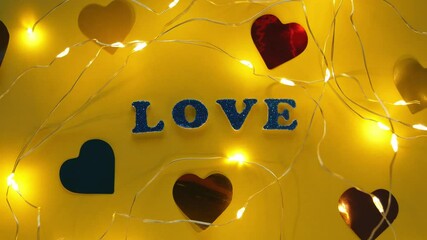 Valentine's Day glitter sign text on pastel yellow background with flying confetti, creative flatlay minimal concept. 4K greeting card top view social media sale banner design. Bright vebrant colors.