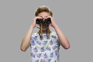 Teenager guy looking through binoculars. Future and perspective concept.