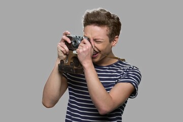 Teen boy using old retro camera. Teenage guy photographing using vintage camera. Hobby concept.