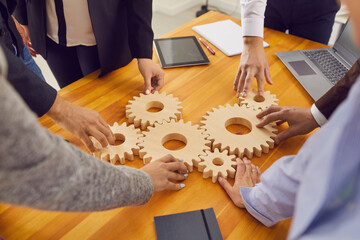 Company workers joining gear wheels as metaphor for effective teamwork and finding working solutions - obrazy, fototapety, plakaty