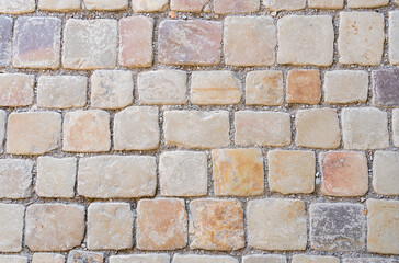 Granite cobblestoned pavement background. Full frame of regular square cobbles in rows. Natural stone textured background