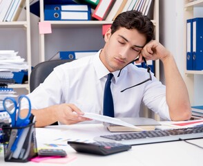 Businessman working in the office with piles of books and papers