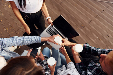 Top view of group of young cheerful friends that is outdoors having fun together