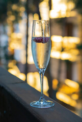 Terrace, Glass with champagne on a wooden table.