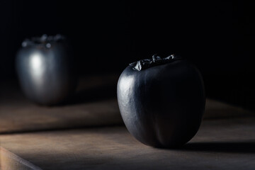 Artistic approach of silver persimmons on a wood.