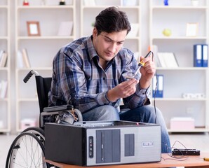 Disabled man on wheelchair repairing computer
