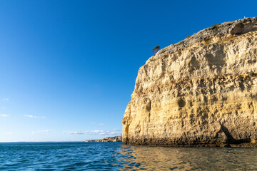 Fototapeta na wymiar rock and cliff coast under a brigh blue sky with sea caves on the Atlantic coast