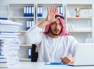 Fototapeta premium Arab businessman working in the office doing paperwork with a pi