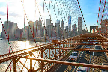 Goldene Stunde in New York City mit Blick auf die Hochhäuser und Skyline von Manhattan von der Brooklyn Bridge aus mit Auto Verkehr und dem East River