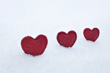 red homemade woolen hearts on white fluffy snow in winter, concept of love, valentine's day, first snow, i love winter, free space for text,
