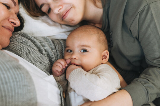 Real Family Of Young Mom And Two Kids Of Different Ages Teenager Girl And Baby Boy Having Fun On The Bed