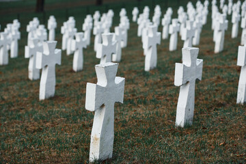 Cemetery with many of white memorial crosses of unnamed people. Conception of death