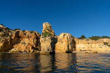 Fototapeta na wymiar the beaches and cliifs of the Algarve Coast in Portugal under bright blue sky
