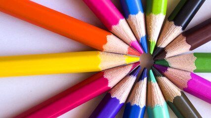 Colored pencils placed in circles on a white background.