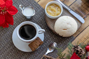 Vista superior de una taza de café, crema y pan con mermelada sobre una mesa