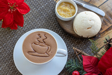 Vista superior de una taza de chocolate caliente y pan con mermelada sobre una mesa