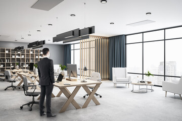 Businessman standing in panoramic open space modern office