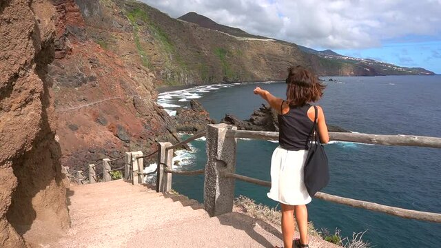 A young woman walking towards the beach of Nogales in the east of the island of La Palma, Canary Islands. Spain