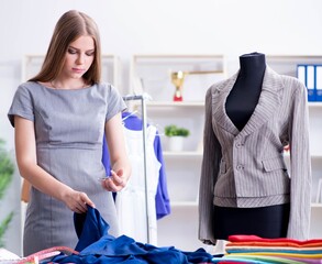 Young woman tailor working in workshop on new dress