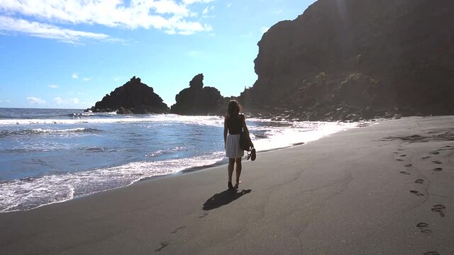 A young tourist walking one summer morning along the beach of Nogales in the east of the island of La Palma, Canary Islands. Spain