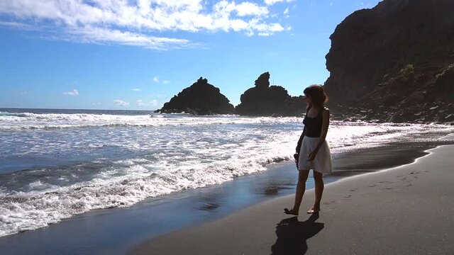 A young tourist walking along the beach of Nogales in the east of the island of La Palma, Canary Islands. Spain