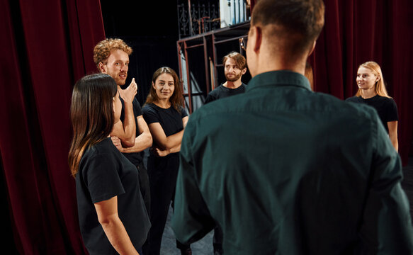 Working together. Group of actors in dark colored clothes on rehearsal in the theater