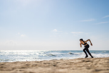 Asian healthy sport athlete girl running or jogging on beach in morning