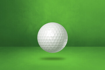 White golf ball on a green studio background