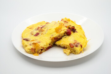 Closeup of homemade omelette pieces with peppers in a white plate
