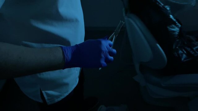 Woman mutant pull a tooth out in dental clinic.