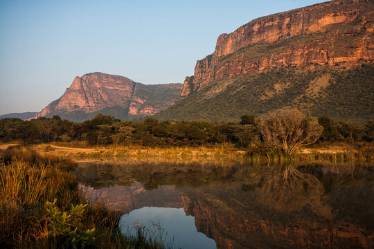 Landscape at sunrise with mountains and a lake which gives a nice reflection in Entabeni Game Reserve in the Waterberg Area in South Africa