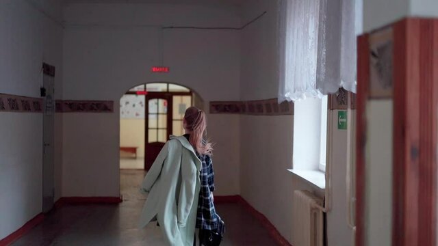 A High School Girl Runs With A Backpack Along The School Corridor To The Classroom. Be Late For Class.