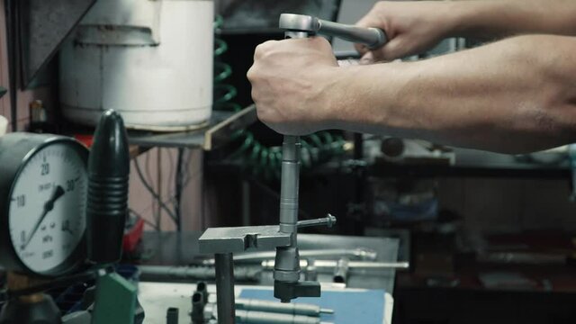Diagnostics and repair of car nozzles. A male mechanic assembles parts of a nozzle in a workshop. Close up.