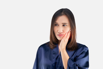 Suffering from toothache. Beautiful young woman suffering from toothache while standing against...