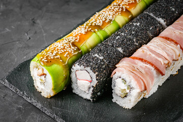 appetizing set of sushi roll on a black stone plate