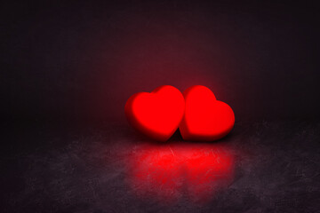 Fototapeta premium 2 red hearts on black textured background
