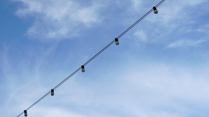 line of bulb lights against blue sky