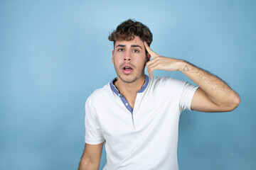 Young handsome man wearing a white t-shirt over blue background having an idea.