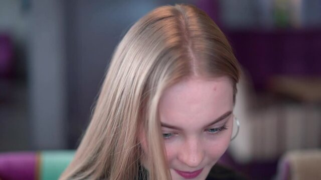 A charming long-haired blonde woman in an awkward position at a restaurant table. difficult conversation. difficult negotiations.