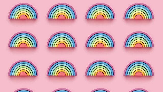 Colorful Waldorf wooden rainbow on pink background in a montessori teaching pedagogy on pink background pattern stopmotion top view