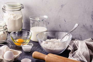 Cooking ingredients for dough, eggs, flour, sugar, milk.