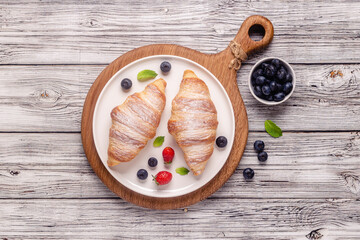Breakfast with croissants and fresh fruits.