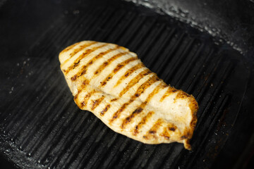 Cook grilling fresh chicken breast.