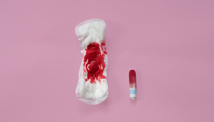 Used feminine pad and tampon on a pink background. Choosing between tampon and panty liner. Female menstruation concept. top view. copy space © Татьяна Григорьева