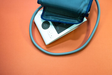 Blood pressure meter close up shot on orange background, space for text.
